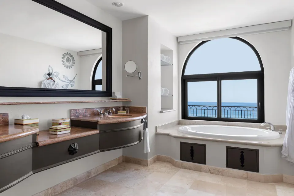 Altamar Governor Suite bathroom with tub, vanity, and ocean view at Hilton Los Cabos.