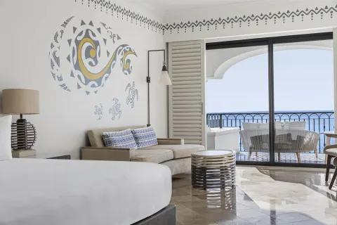 Altamar Junior Suite with king bed, sofa, balcony, and ocean view at Hilton Los Cabos.