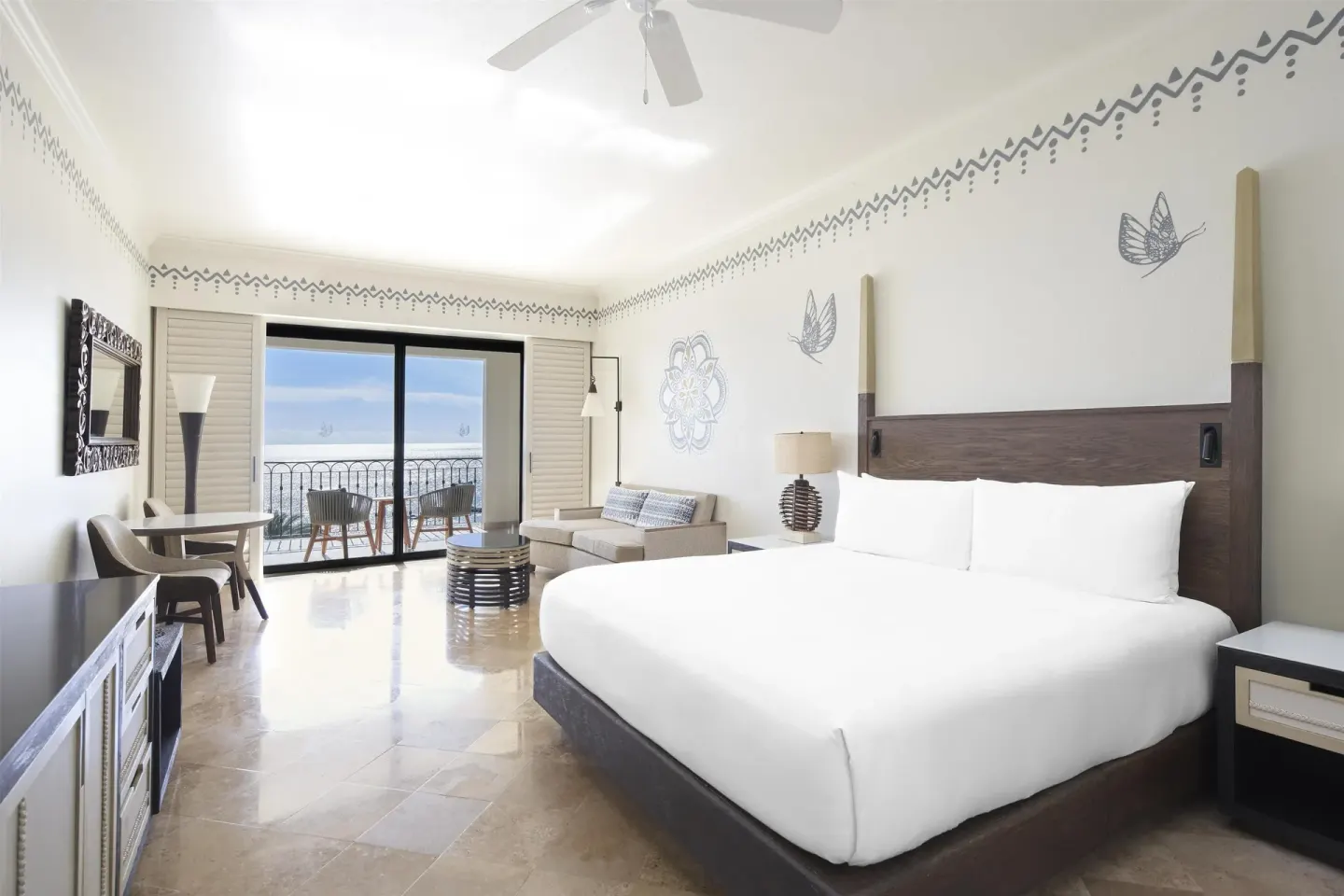 Altamar Junior Suite king bed with seating, desk, and balcony at Hilton Los Cabos.