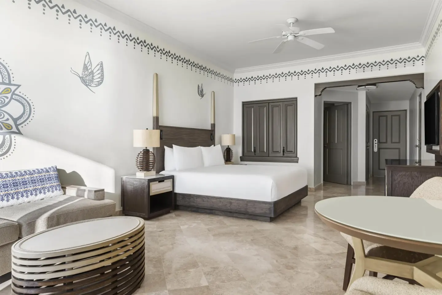 Altamar Junior Suite with king bed, sofa, coffee table, and dining table at Hilton Los Cabos.