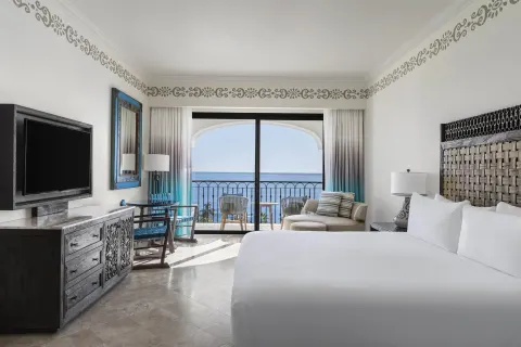 Altamar Premier Suite king bed, TV, desk and ocean balcony at Hilton Los Cabos.