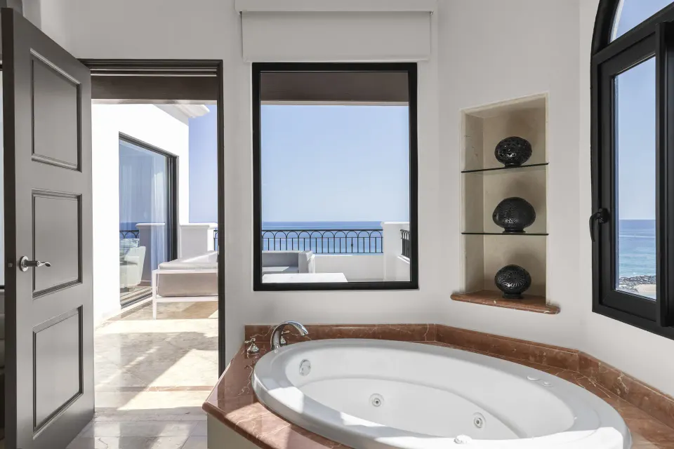 Close view of the Altamar Presidential Suite soaking tub at Hilton Los Cabos beside ocean-view windows.
