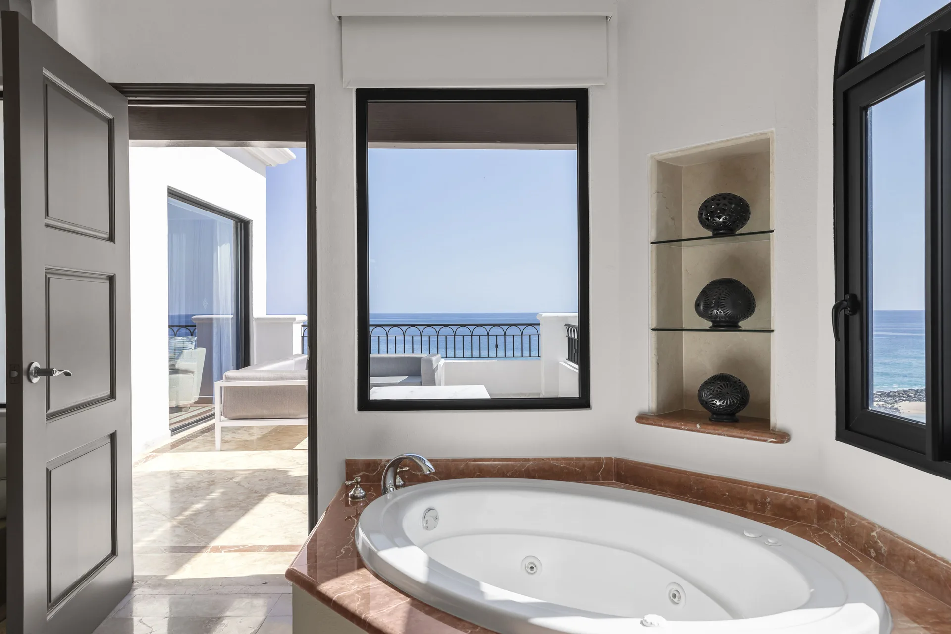 Close view of the Altamar Presidential Suite soaking tub at Hilton Los Cabos beside ocean-view windows.