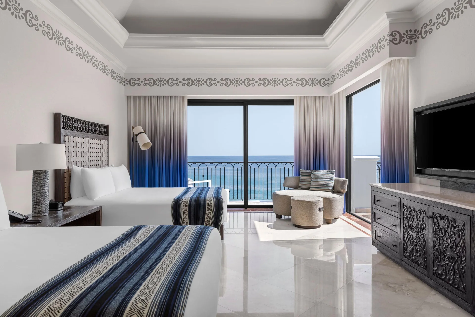 Two-bed guest room in the Altamar Presidential Suite at Hilton Los Cabos facing an ocean balcony.