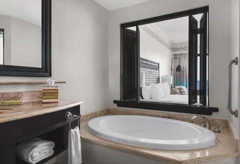Accessible bathroom soaking tub with pass-through view to the room at Hilton Los Cabos.