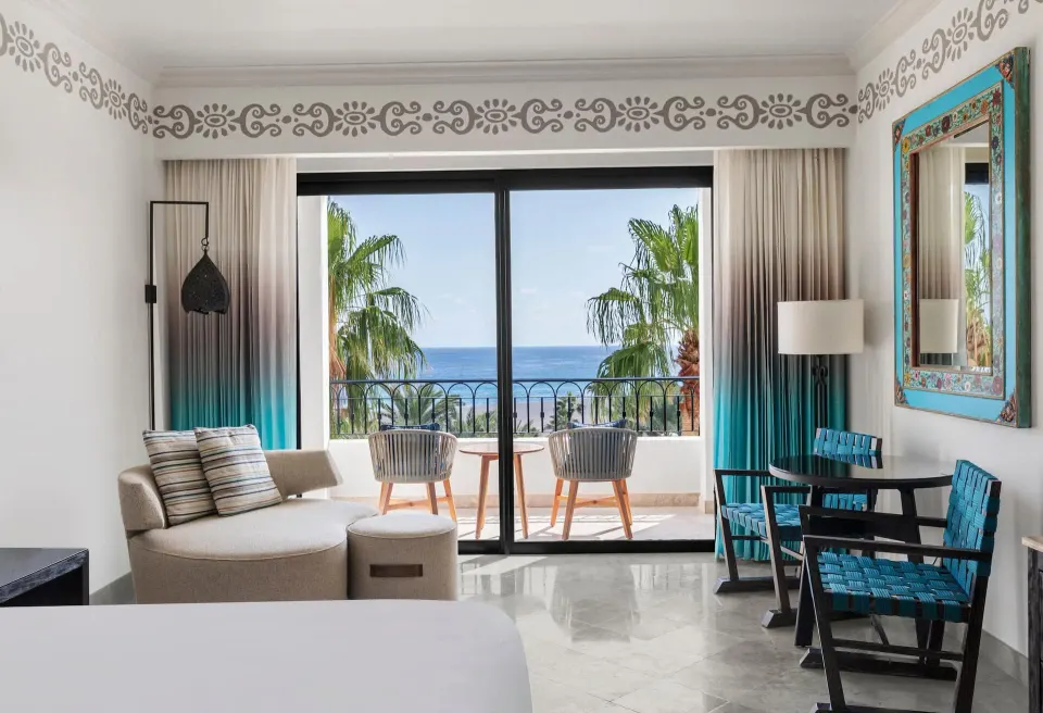 Deluxe Mobility Accessible room seating area and balcony ocean view at Hilton Los Cabos.