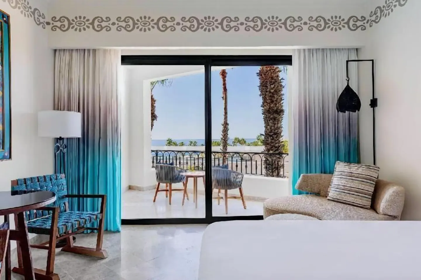 Deluxe Room Coastal Garden View balcony seating at Hilton Los Cabos seen from inside the room.
