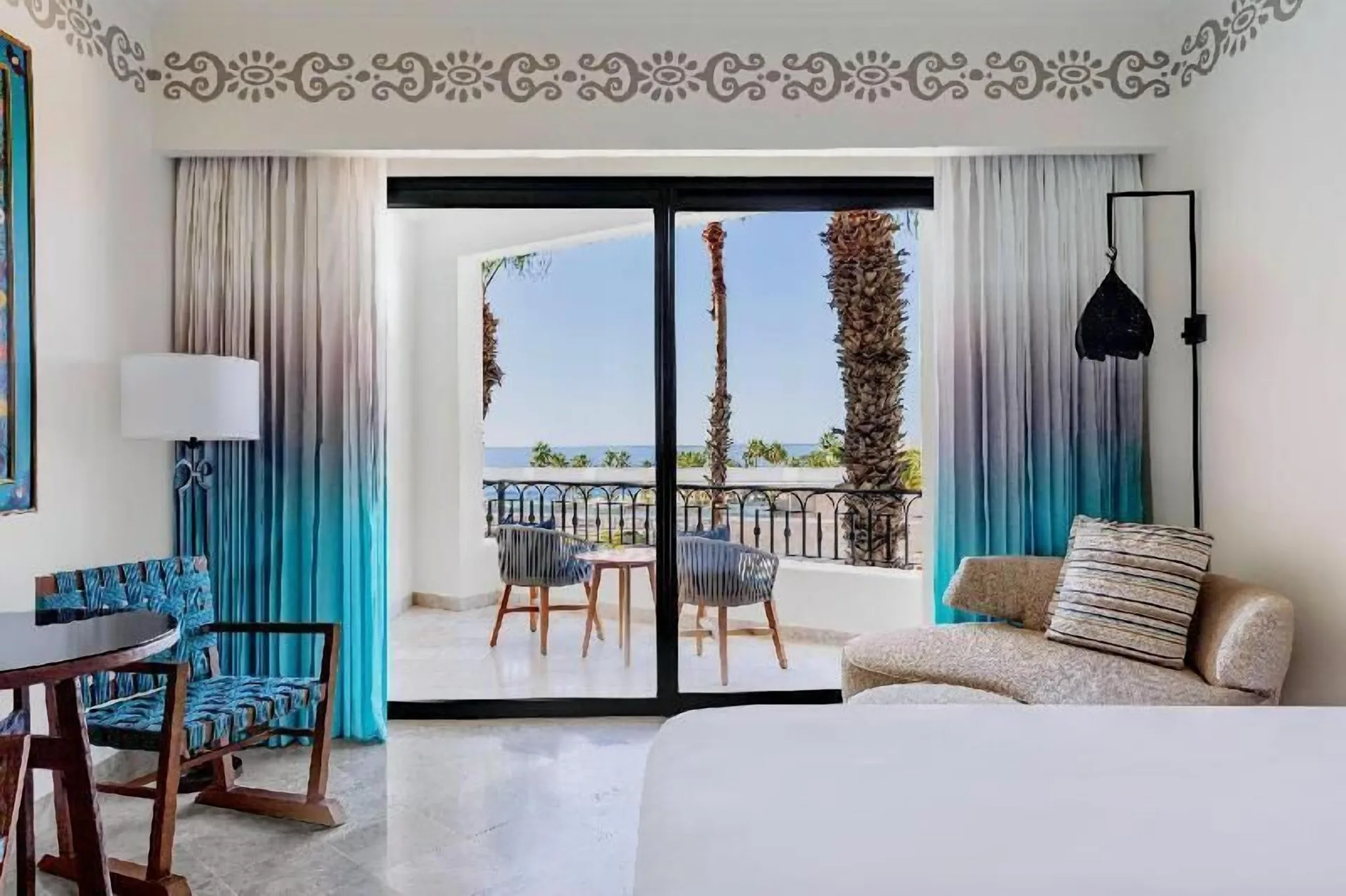 Deluxe Room Coastal Garden View balcony seating at Hilton Los Cabos seen from inside the room.