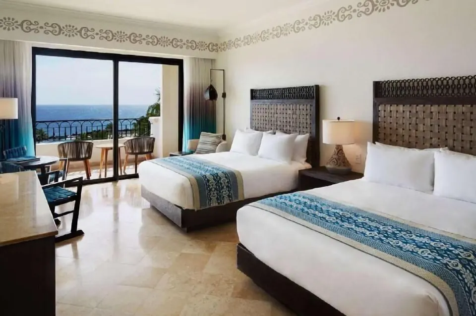 Deluxe Room Coastal Garden View two beds at Hilton Los Cabos with balcony and ocean view.
