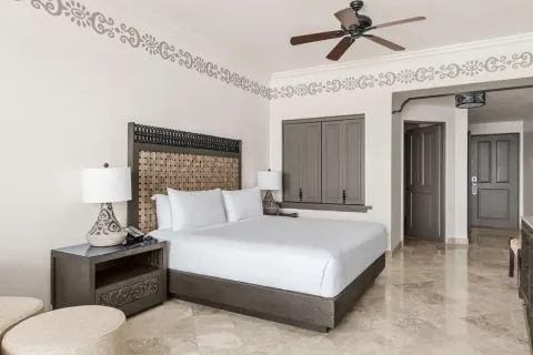 Deluxe Room Ocean View king bed and bedside lamps at Hilton Los Cabos.