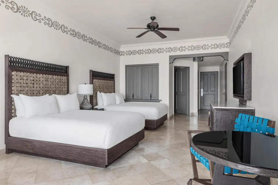 Deluxe Room Ocean View with two beds and dining table at Hilton Los Cabos.