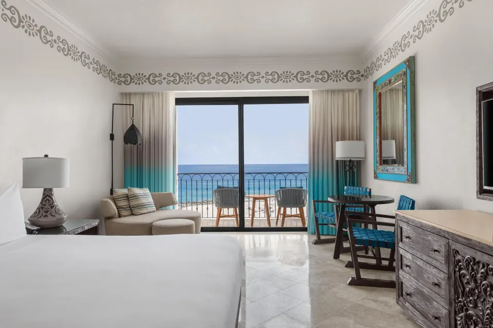 Deluxe oceanfront king room seating and balcony view at Hilton Los Cabos.
