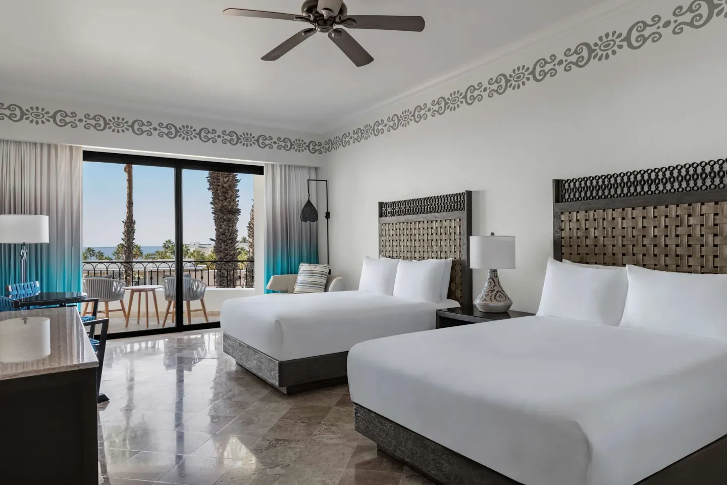Deluxe Room with two beds and balcony seating at Hilton Los Cabos.