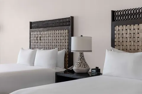 Deluxe Room two-bed detail with woven headboards at Hilton Los Cabos.