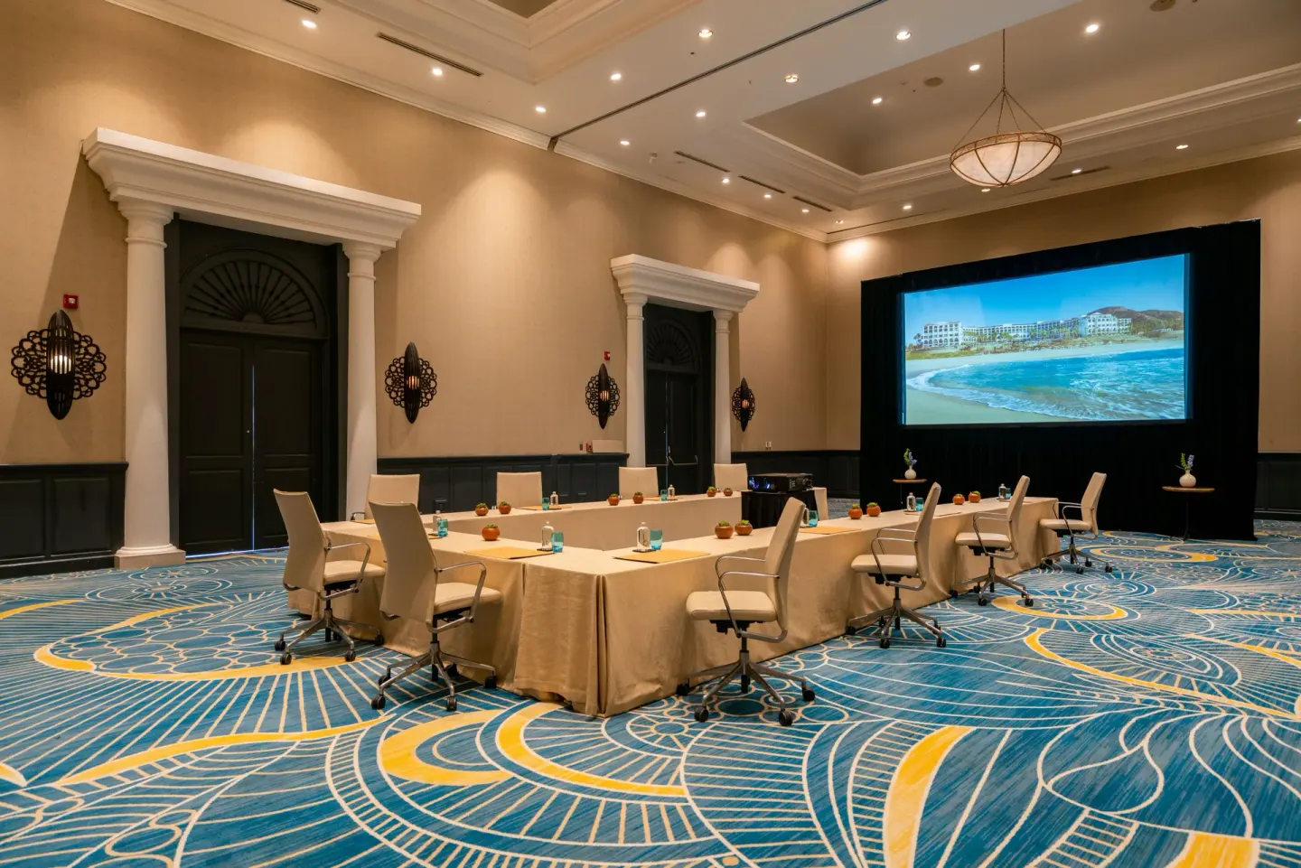 Conference room with U-shaped meeting tables and projection screen at Hilton Los Cabos.
