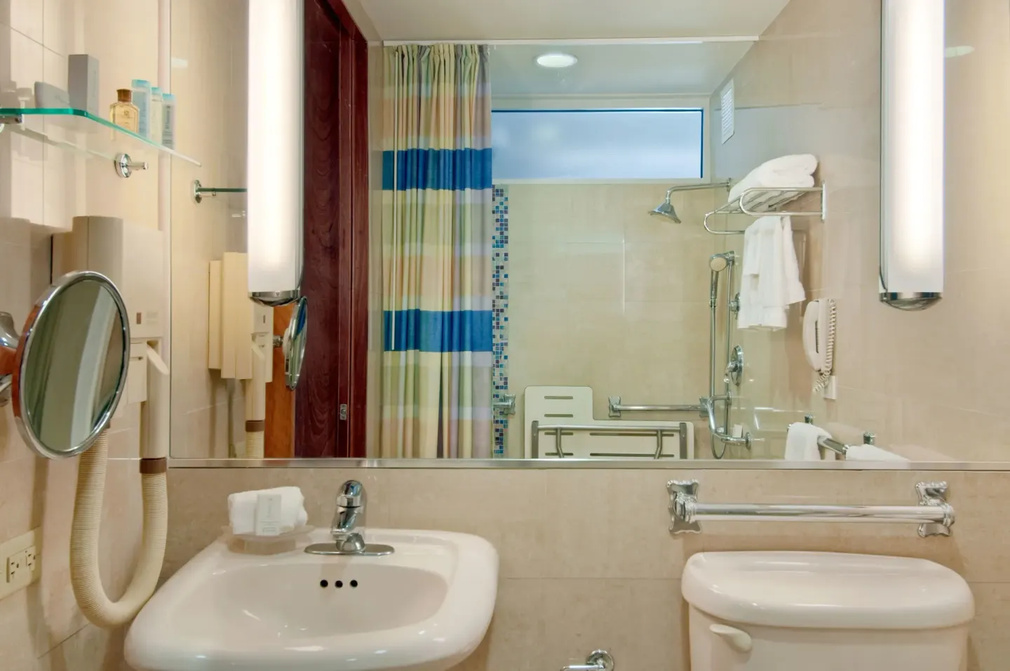 Bathroom with sink, mirror and accessible shower at Hilton Ponce Golf & Casino Resort.