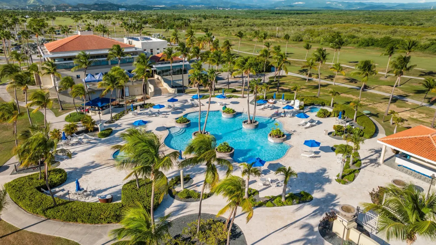 Aerial view of the pool, palms and golf course at Hilton Ponce Golf & Casino Resort.
