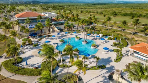 Aerial view of the pool, palms and golf course at Hilton Ponce Golf & Casino Resort.