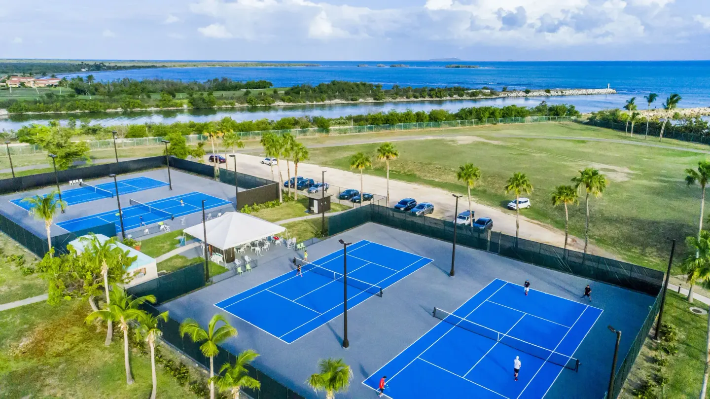 Aerial tennis courts by the coast at Hilton Ponce Golf & Casino Resort.