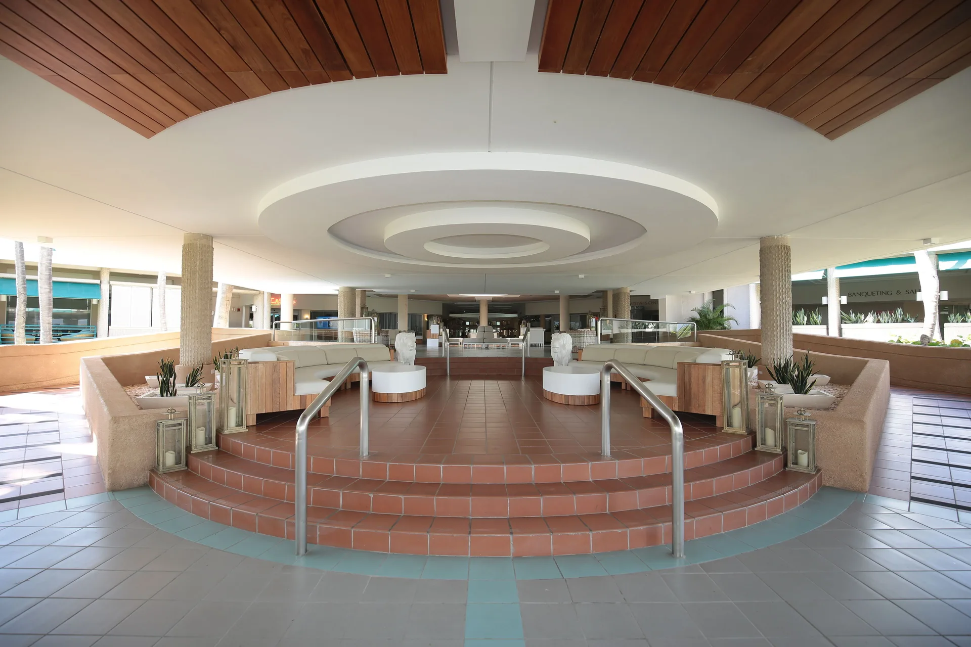 Covered lobby approach with tiled steps and lounge seating at Hilton Ponce Golf & Casino Resort.