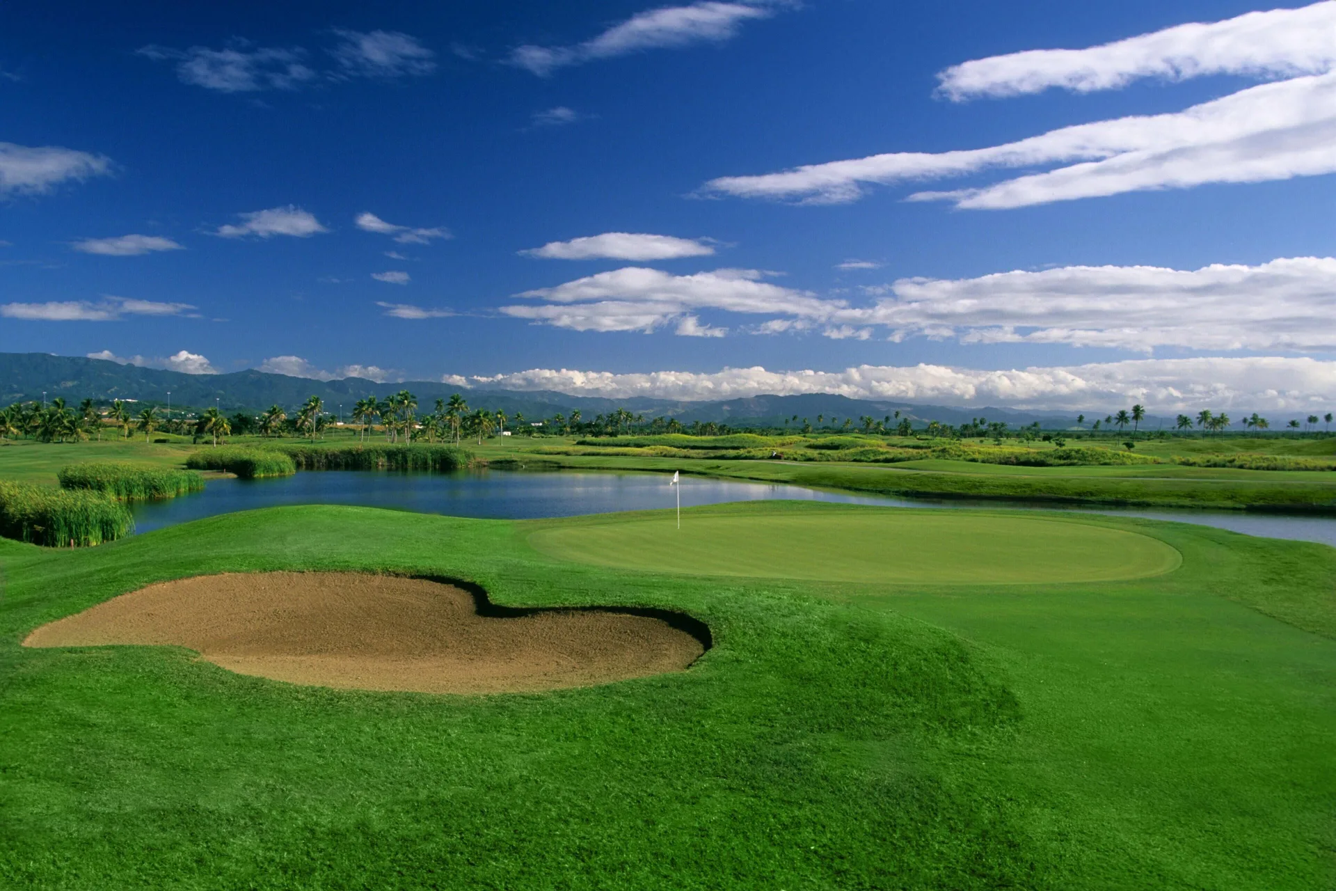 Golf green, sand bunker and lagoon at Hilton Ponce Golf & Casino Resort.
