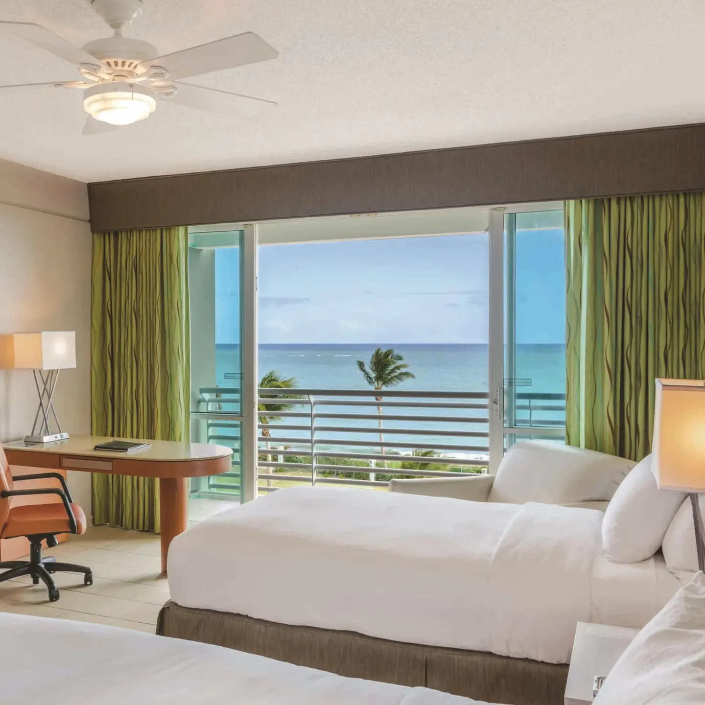 Guest room with two beds and an ocean-facing balcony at Hilton Ponce Golf & Casino Resort.