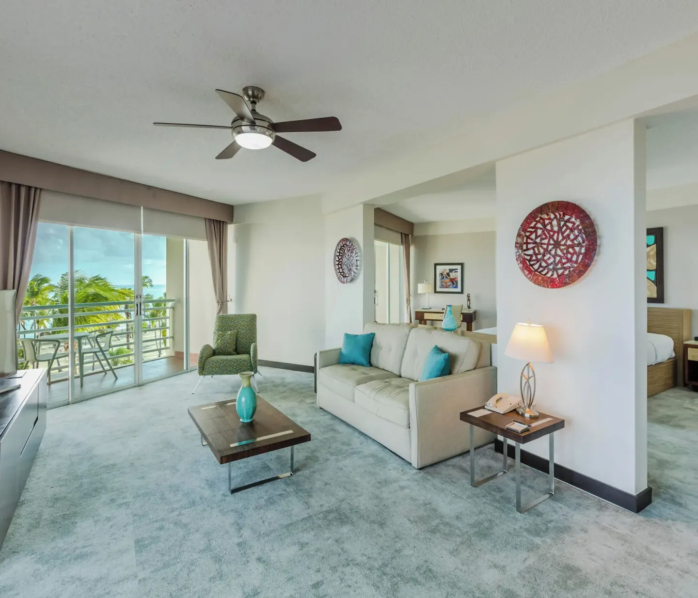 Suite living area with sofa, balcony, and ocean view at Hilton Ponce Golf & Casino Resort.