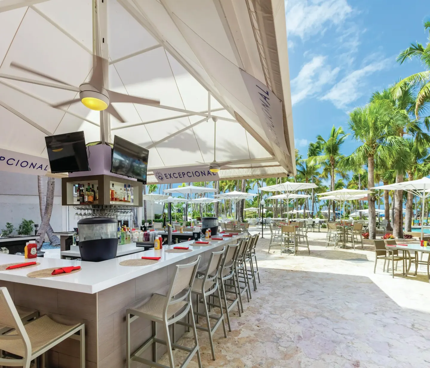Outdoor poolside bar and patio seating at Hilton Ponce Golf & Casino Resort.