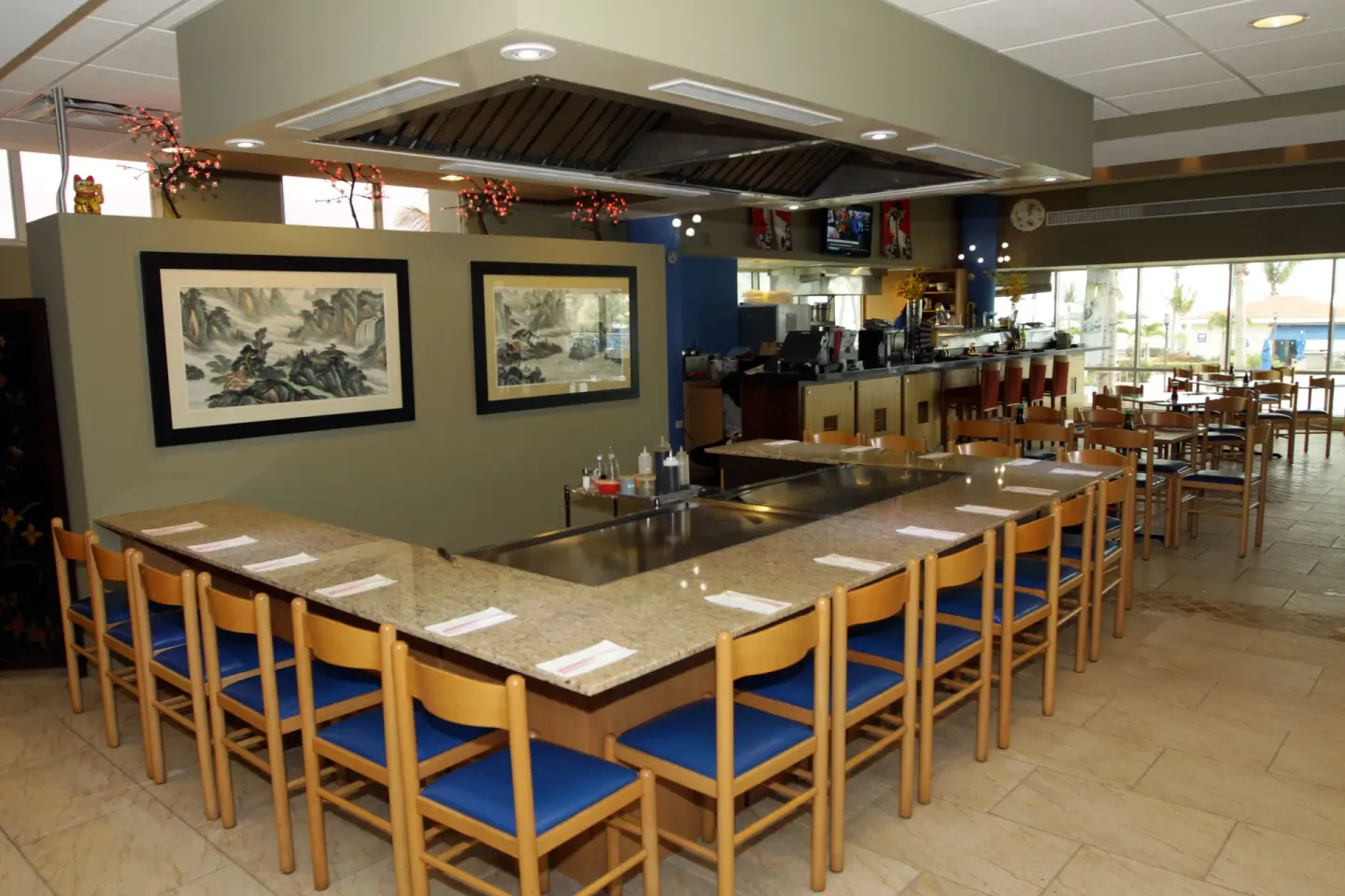 A teppanyaki counter with blue seats is set for dining at Hilton Ponce Golf & Casino Resort.