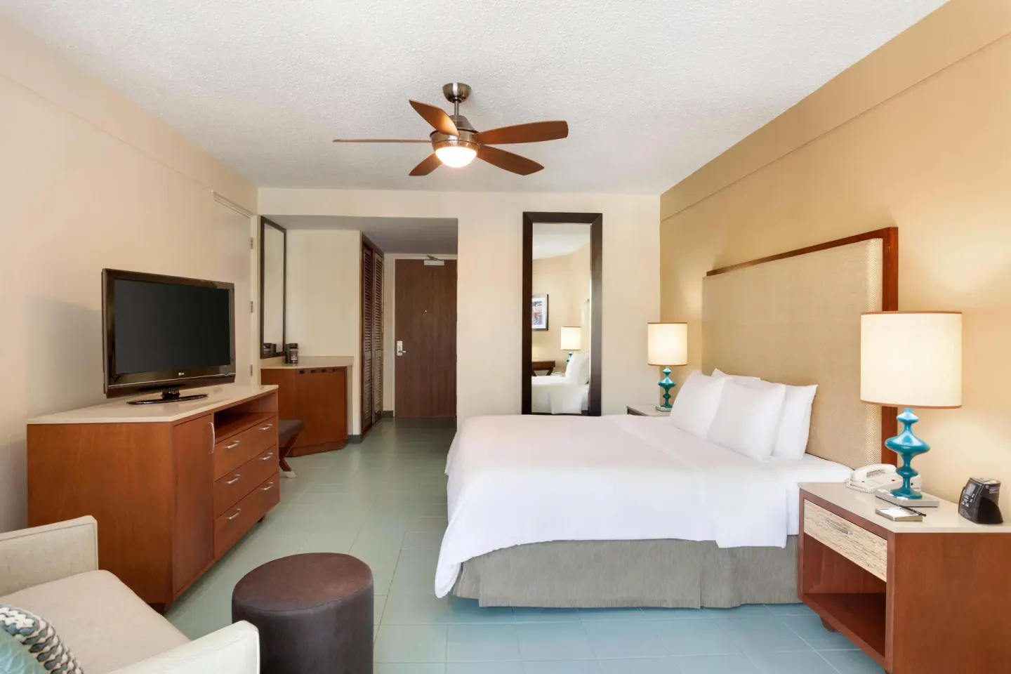 King bed guest room with TV and entry area at Hilton Ponce Golf & Casino Resort.