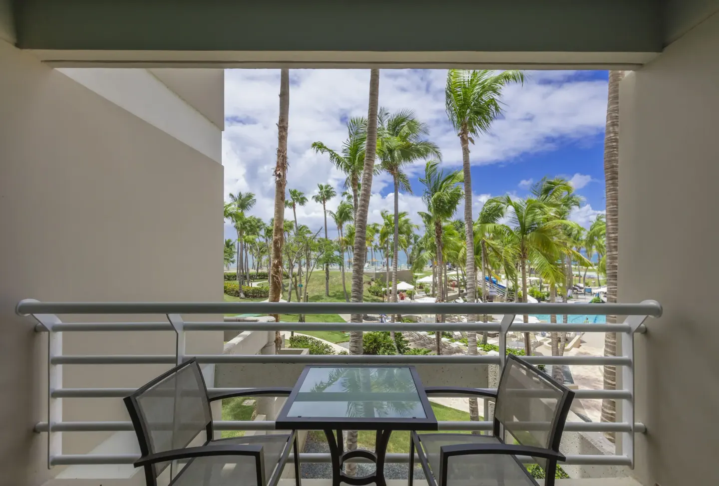 Balcony pool view room terrace with chairs at Hilton Ponce Golf & Casino Resort.