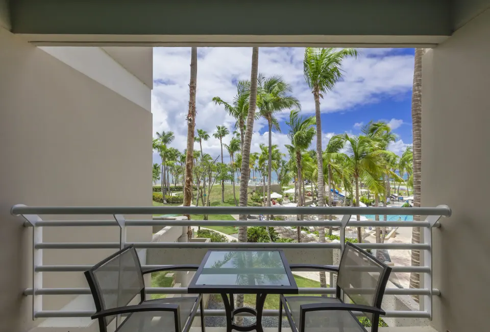 Balcony pool view room terrace with chairs at Hilton Ponce Golf & Casino Resort.