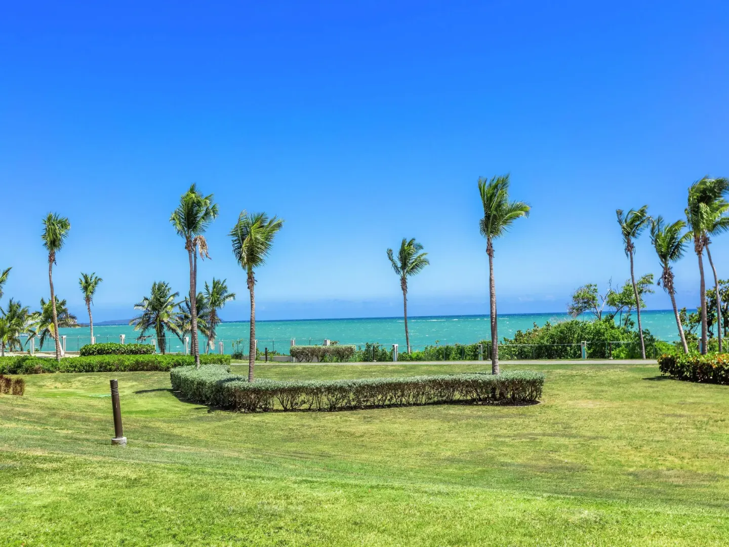 Garden lawn and ocean view from a guest room area at Hilton Ponce Golf & Casino Resort.