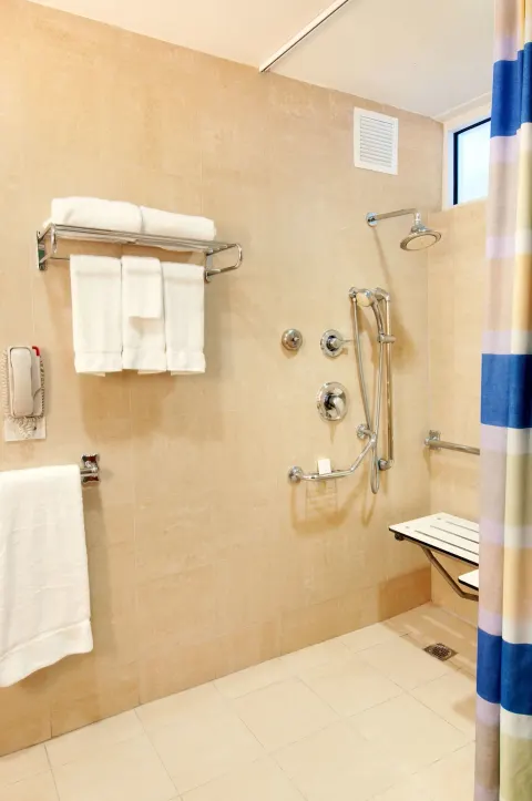 Accessible roll-in shower with grab bars at Hilton Ponce Golf & Casino Resort.