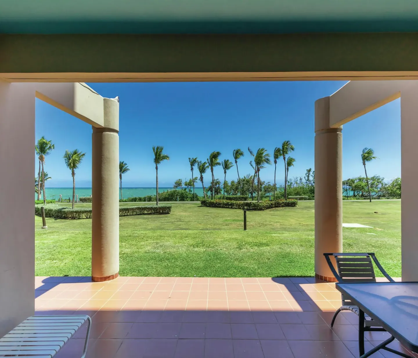 Covered patio with lawn and ocean view at Hilton Ponce Golf & Casino Resort.