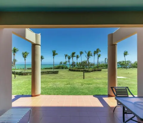 Covered garden patio with palms and ocean beyond at Hilton Ponce Golf & Casino Resort.