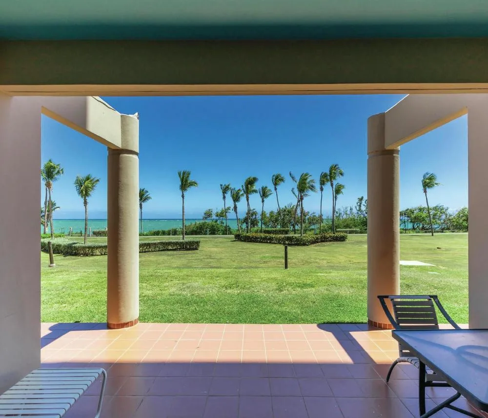 Covered garden patio with palms and ocean beyond at Hilton Ponce Golf & Casino Resort.