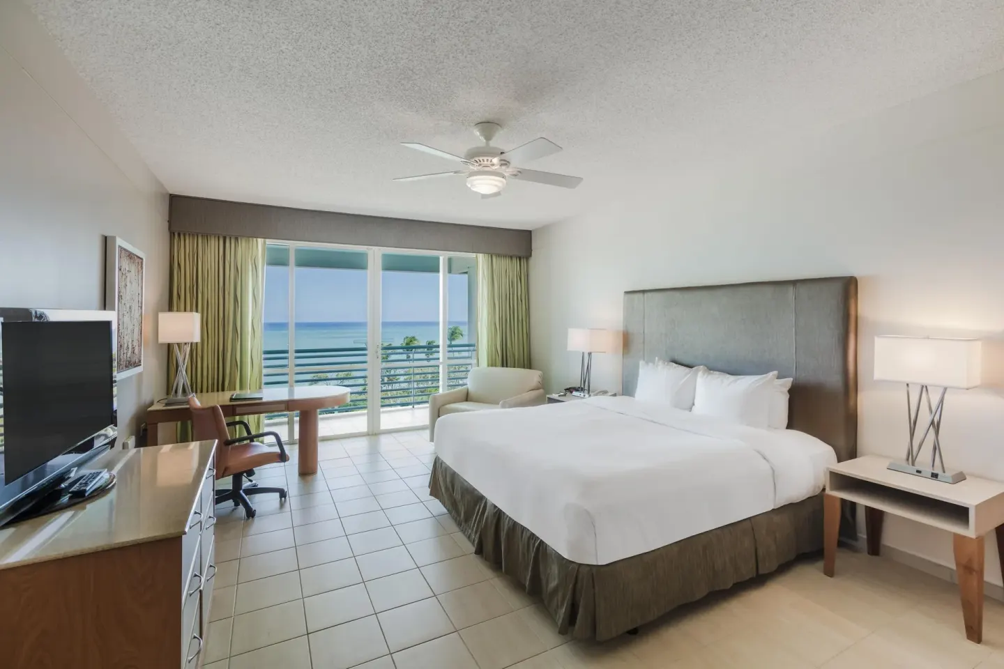 Ocean Tower suite king bedroom with balcony ocean view at Hilton Ponce Golf & Casino Resort.