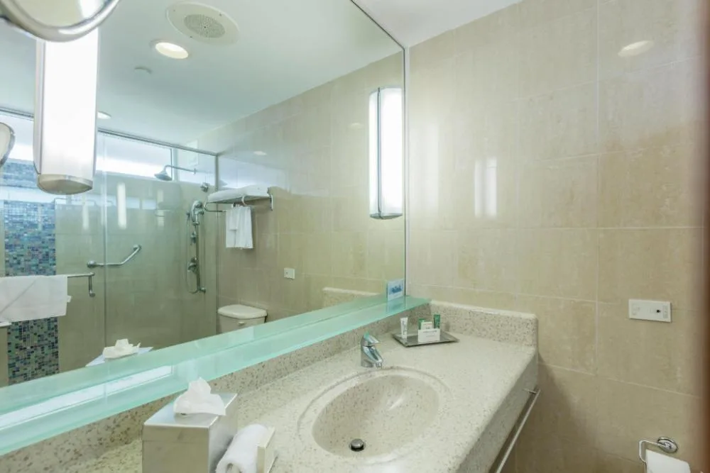 Guest bathroom with vanity and glass shower at Hilton Ponce Golf & Casino Resort.