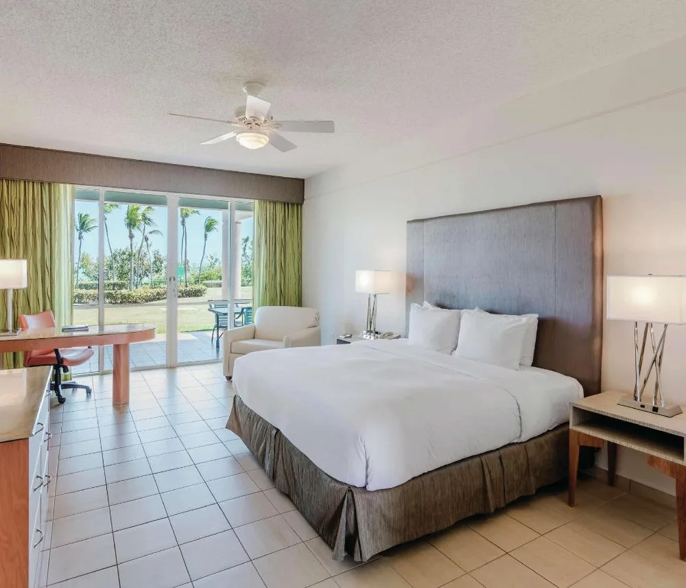 Oceanfront deluxe patio king room with desk and bed at Hilton Ponce Golf & Casino Resort.