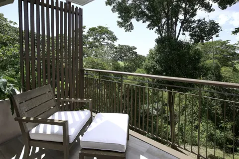 Balcony seating overlooking trees at Hilton Trinidad & Conference Centre.