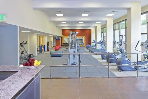 Fitness center with cardio machines and weights at Hilton Trinidad & Conference Centre.