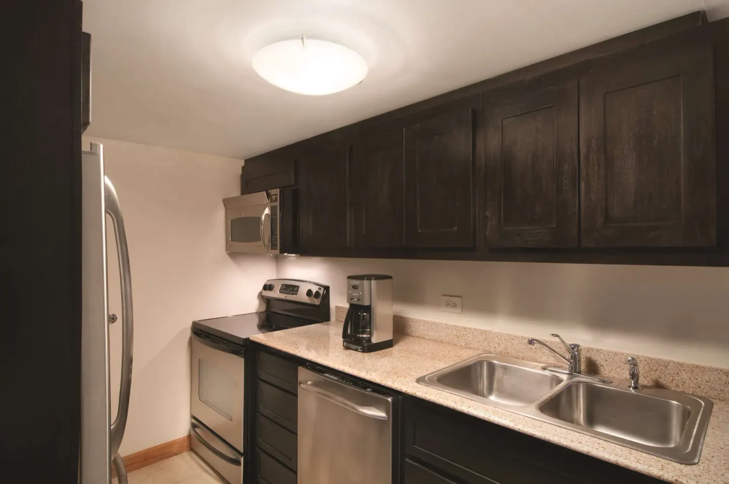 Guest room kitchen with appliances and double sink at Hilton Trinidad & Conference Centre.