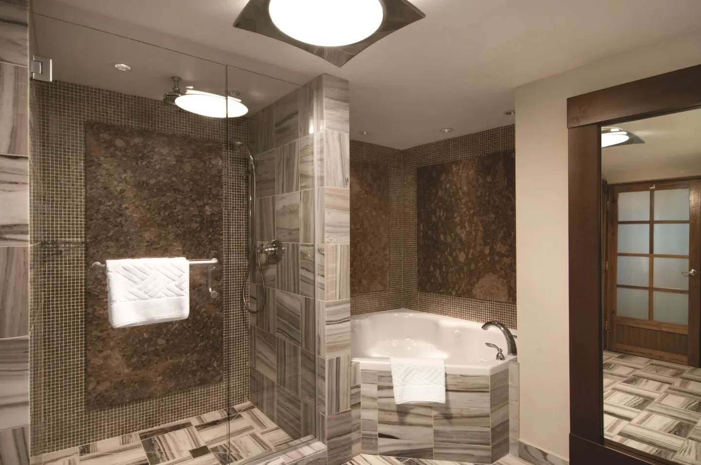 Marble bathroom with glass shower and bathtub at Hilton Trinidad & Conference Centre.