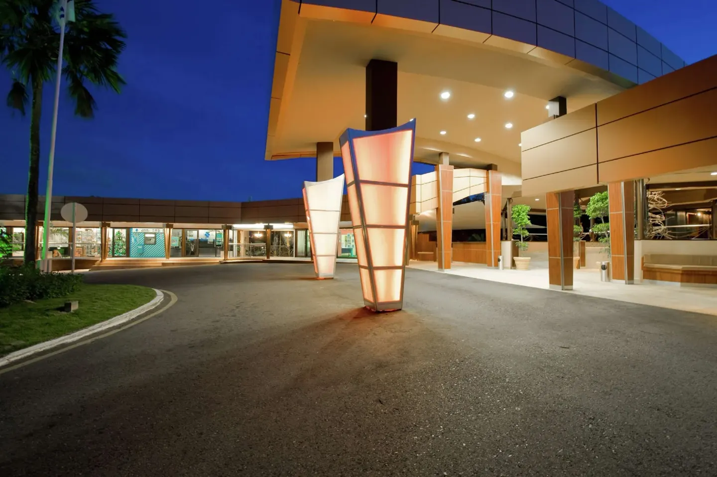 Nighttime arrival driveway and covered entrance at Hilton Trinidad & Conference Centre.