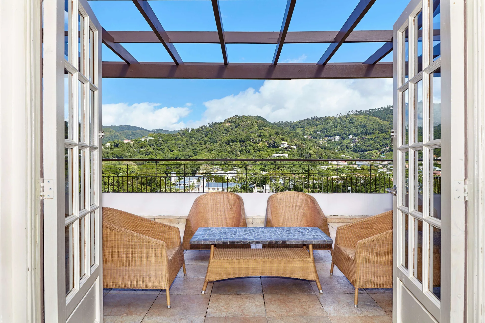 Terrace seating overlooks green hills at Hilton Trinidad & Conference Centre.