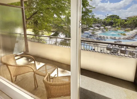 Balcony of a Deluxe Pool View room at Hilton Trinidad & Conference Centre overlooking the pool deck.
