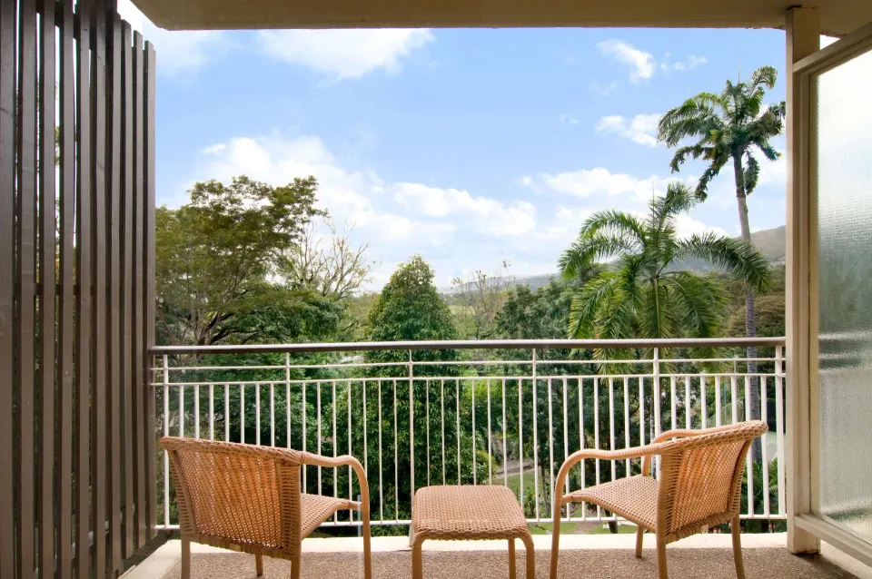Deluxe Room balcony seating with palm trees at Hilton Trinidad & Conference Centre.