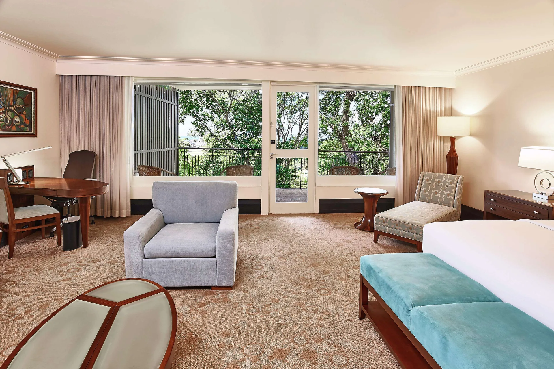 Deluxe Studio Suite with king bed, work desk, and balcony at Hilton Trinidad and Conference Centre in Port of Spain.