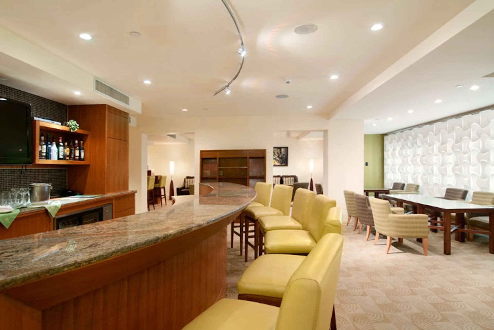 Private lounge bar with counter seating and dining tables at Hilton Trinidad & Conference Centre.